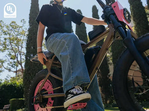 A boy riding a Macfox electric bicycle, photographed from below.