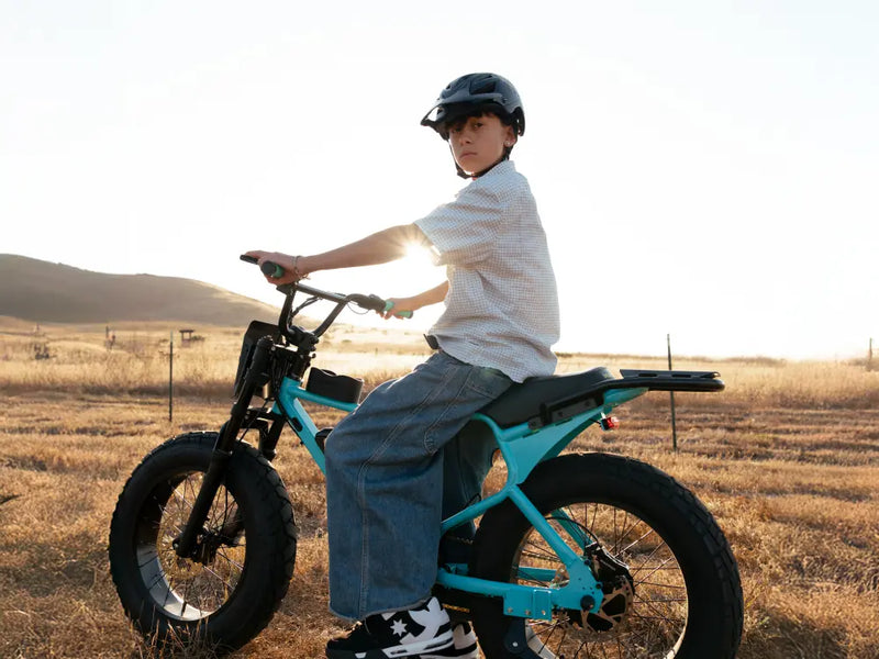 younger rider riding Macfox X7 ebike on open groundin background