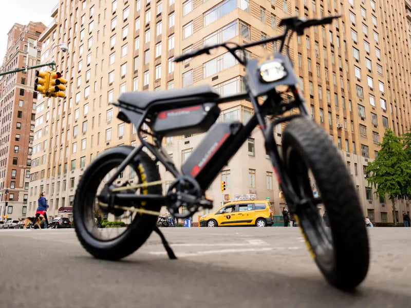 Macfox X1S commuter eBike parked on a city street, highlighting wide urban tires and frame design