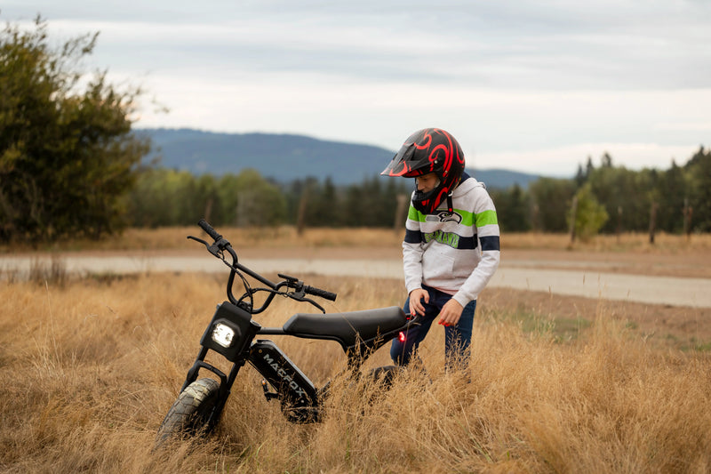 M16 Youth Electric Bicycle placed on weeds. 