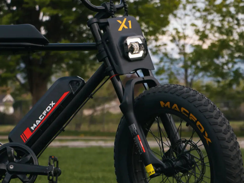 close-up of the front frame and tire on a Macfox X1S ebike parked on grass