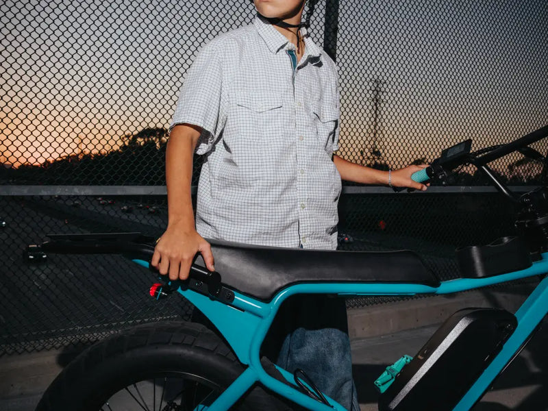 student rider standing beside Macfox X7 ebike with seat visible