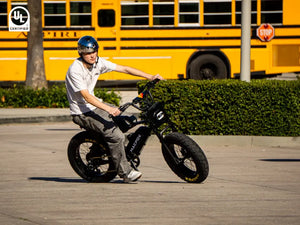 A man is riding a Macfox X7 electric bicycle.