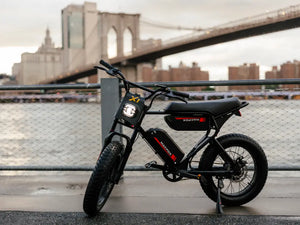 Macfox X1S commuter eBike parked near a city bridge with urban skyline in the background