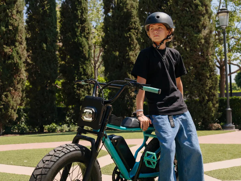younger rider standing beside a Macfox X7 ebike on a residential street