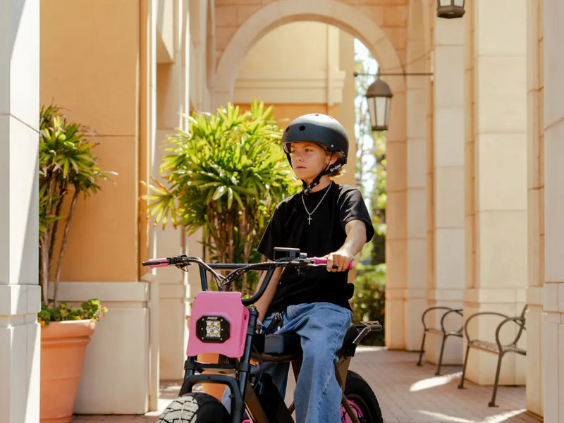 younger rider riding Macfox X7 ebike through an outdoor walkway