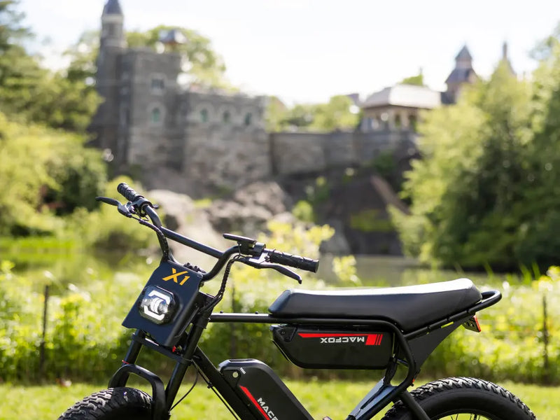 Macfox X1S e-bike parked outdoors near greenery, highlighting the frame and fat-tire setup