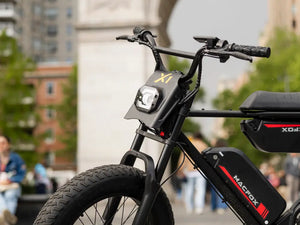 Close-up of a Macfox X1S commuter eBike parked in an urban plaza with buildings behind