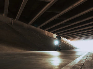 rider riding a Macfox X7 electric bike under a concrete overpass
