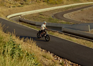 A boy rides a Macfox electric bike outdoors.