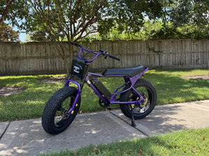 Purple Macfox eBike parked beside a tree-lined neighborhood path.