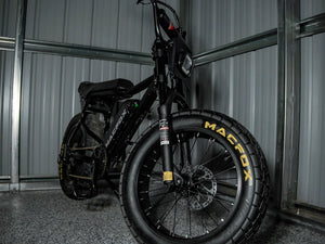 Macfox X7 black electric bike in a dark outdoor lifestyle scene.