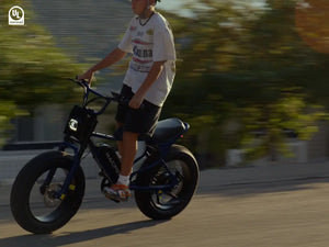 A boy rides a Macfox electric bike on the road.