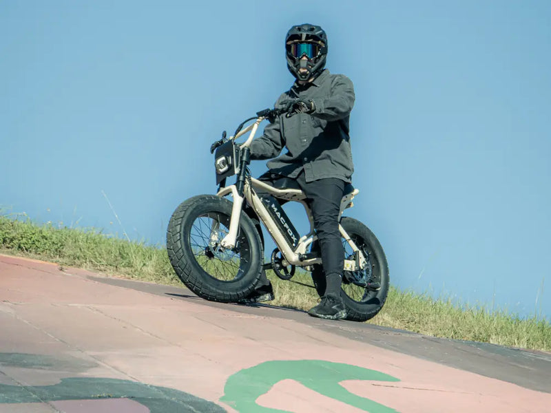 Macfox X7 fat-tire eBike being ridden up a painted concrete slope on a sunny day