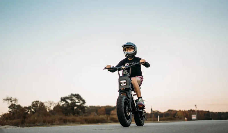 A 16-year-old boy is riding a Class 2 electric bicycle and wearing a helmet.