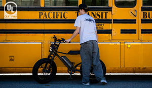 The man is preparing to ride a Macfox X7 electric bicycle.
