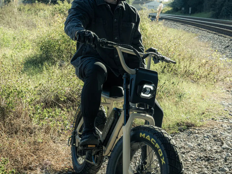 Rider exploring an outdoor trail on a Macfox X7 fat-tire e-bike near grassy terrain