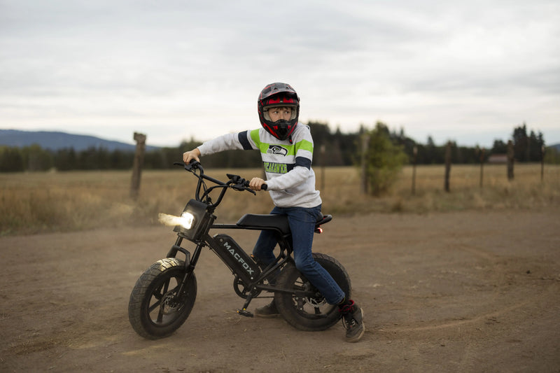 Teen riding the M16 youth electric bike on open road, showing affordable style and independence under $1,000.