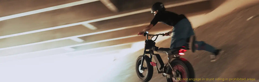 Younger rider riding a Macfox X7 electric bike under an overpass with rear light visible